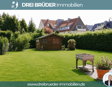 Ein grüner Garten mit einem kleinen Holzhaus und einem Tisch aus Holz ist zu sehen. Im Hintergrund sind Bäume und Wohnhäuser zu erkennen. Der Garten wirkt gepflegt und einladend.