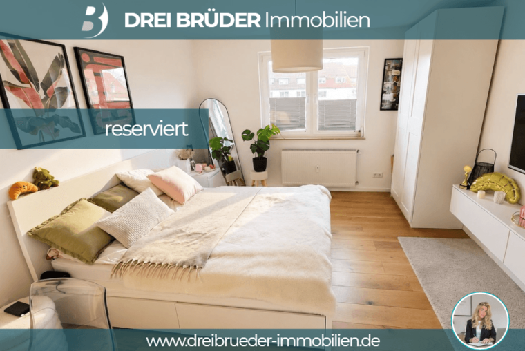 Ein modernes Schlafzimmer mit einem großen Bett, dekorativen Kissen und einer gemütlichen Decke. An der Wand hängen Bilder. Neben dem Bett steht ein kleiner Tisch mit Pflanzen. Es gibt ein Fenster, durch das Tageslicht strömt. Der Raum wirkt hell und einladend.
