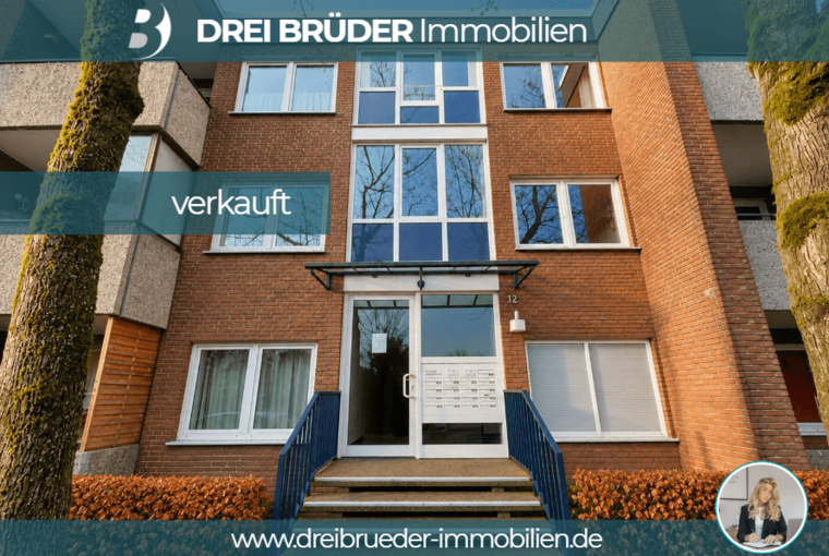 Das Bild zeigt ein mehrstöckiges Wohngebäude aus Backstein mit großen Fenstern. Vor der Eingangstür ist eine Treppe und eine Briefkastenanlage sichtbar. Oben steht der Schriftzug „verkauft“ deutlich in einem blauen Banner.